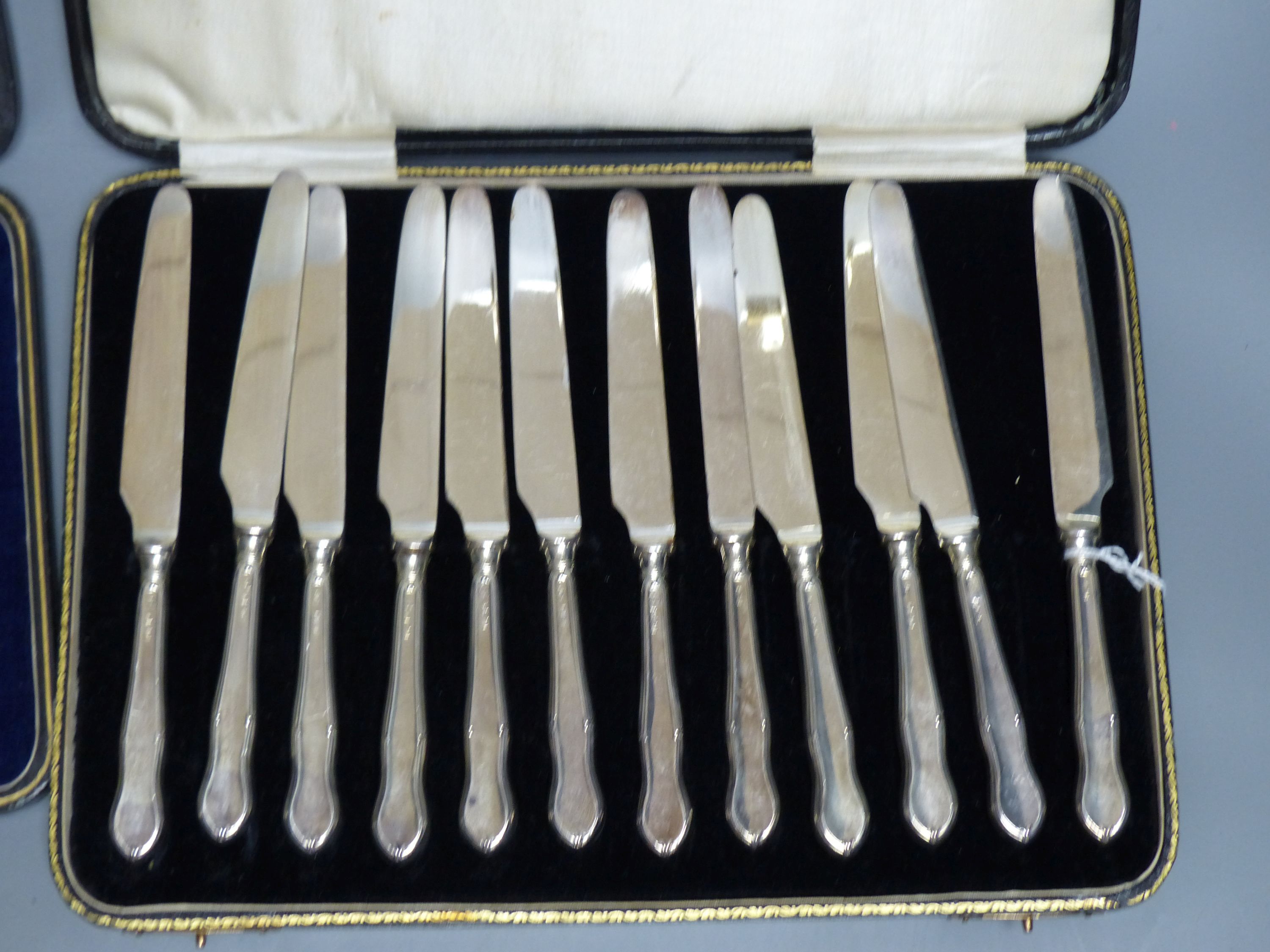 A cased set of twelve silver-handled dessert knives and a cased set of six similar cake forks (Sheffield 1919)